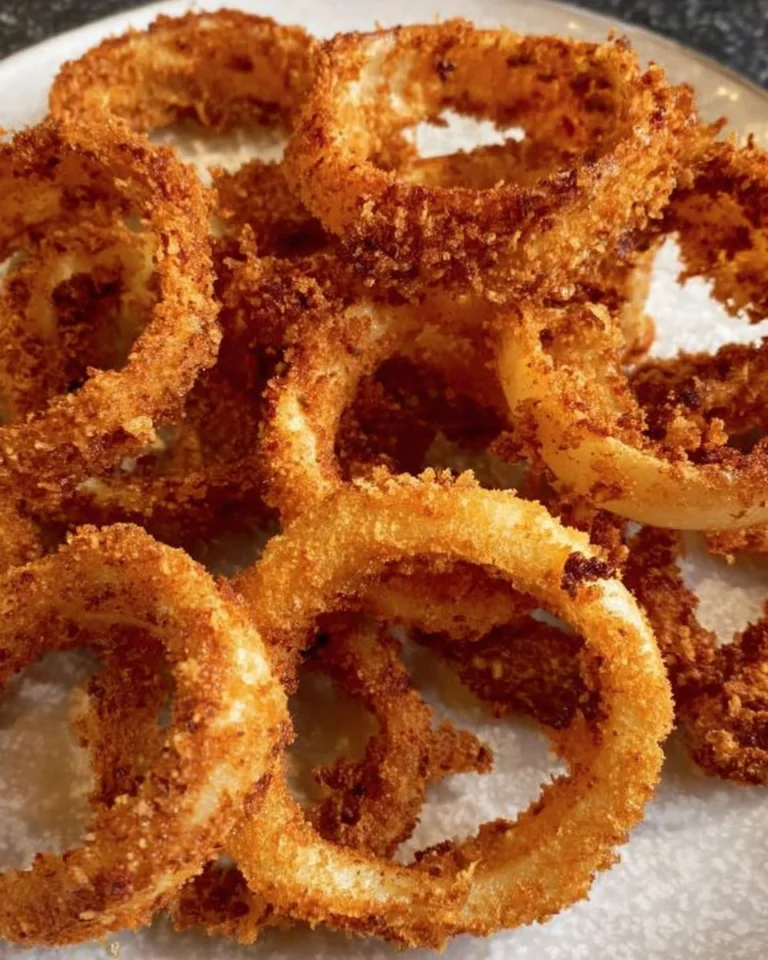 Crispy air fried onion rings served on a plate with dipping sauce