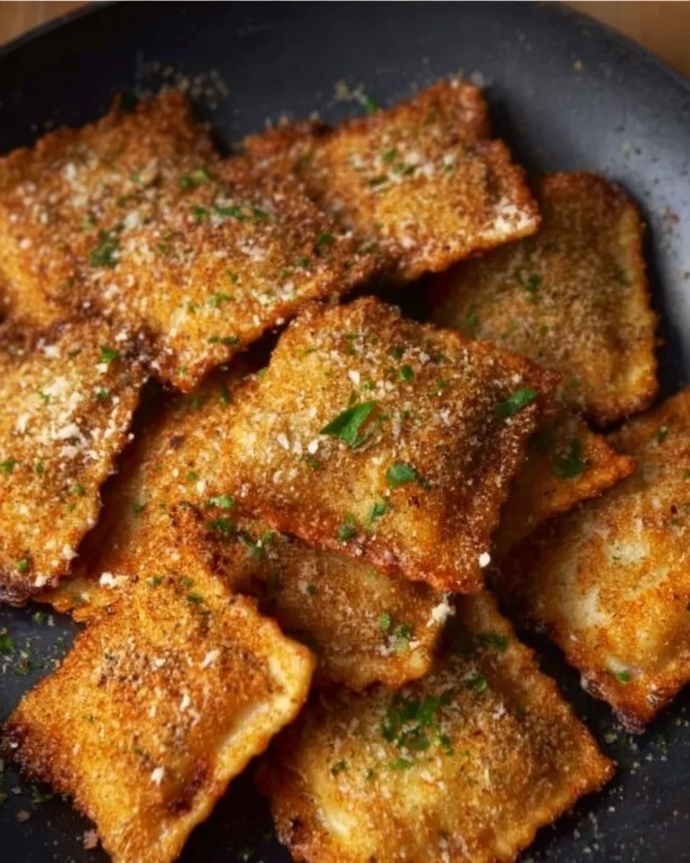 Crispy toasted ravioli served with marinara sauce on a plate.