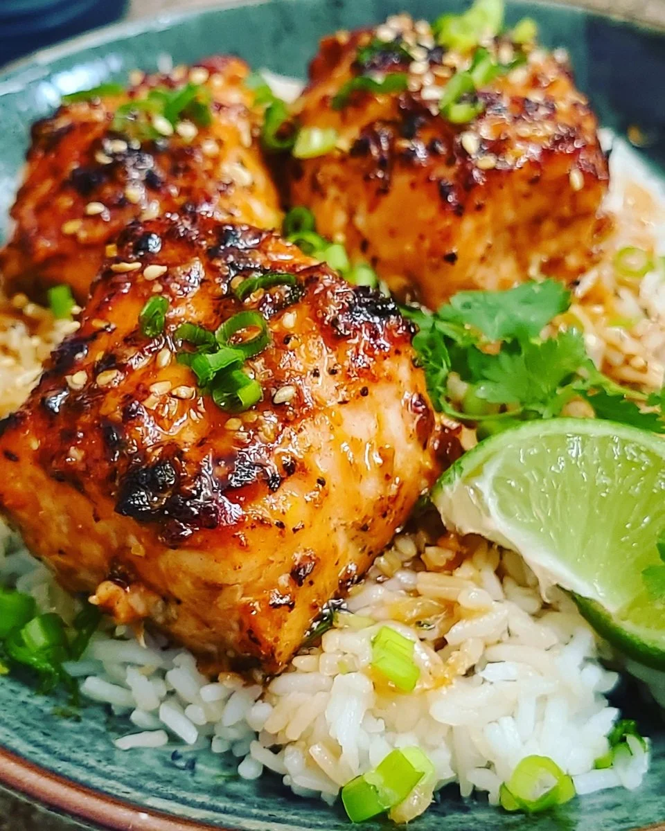 Plate of Bang Bang Salmon garnished with green onions and served with rice.