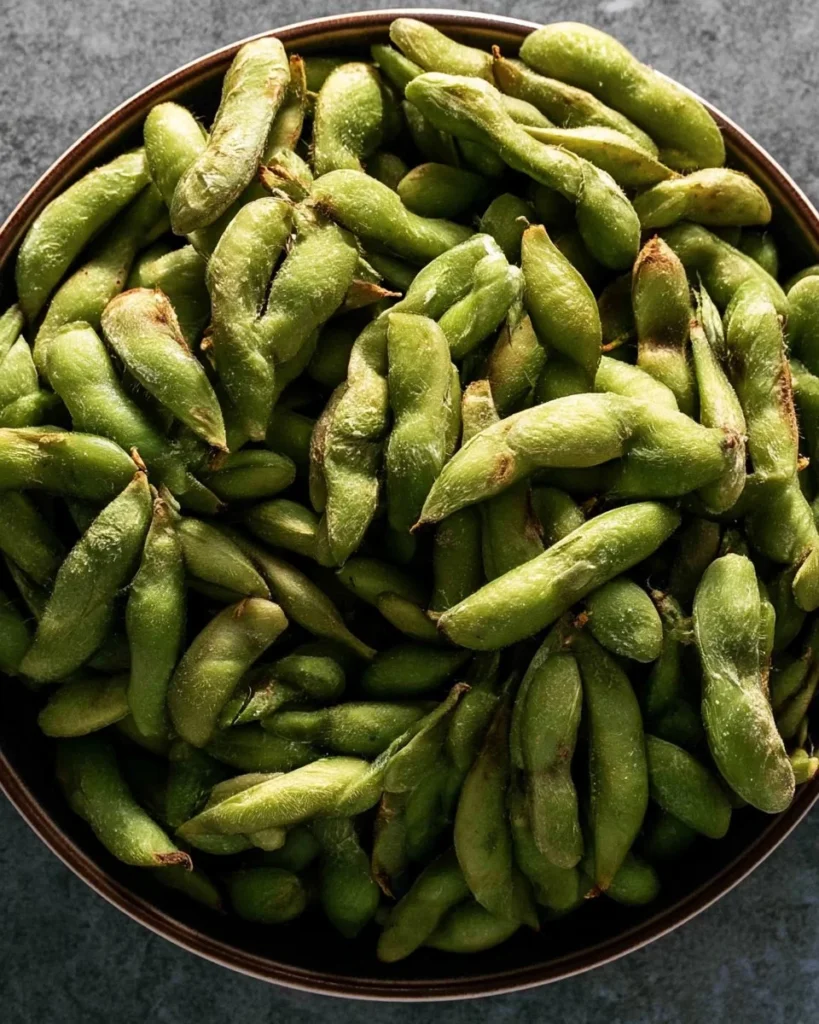 A bowl of air-fried frozen edamame ready to eat, healthy snack option.