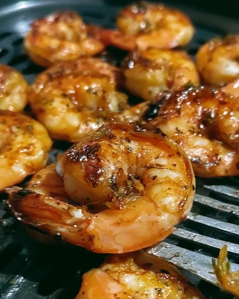 Delicious air fryer shrimp served on a plate with garnishes and dipping sauce